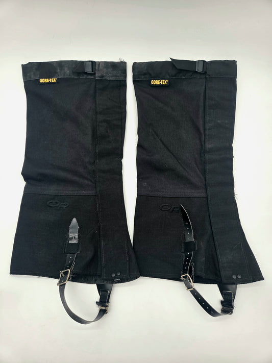 A pair of black GORE-TEX insulated gaiters with adjustable black straps and metal buckles, laid flat on a white background.